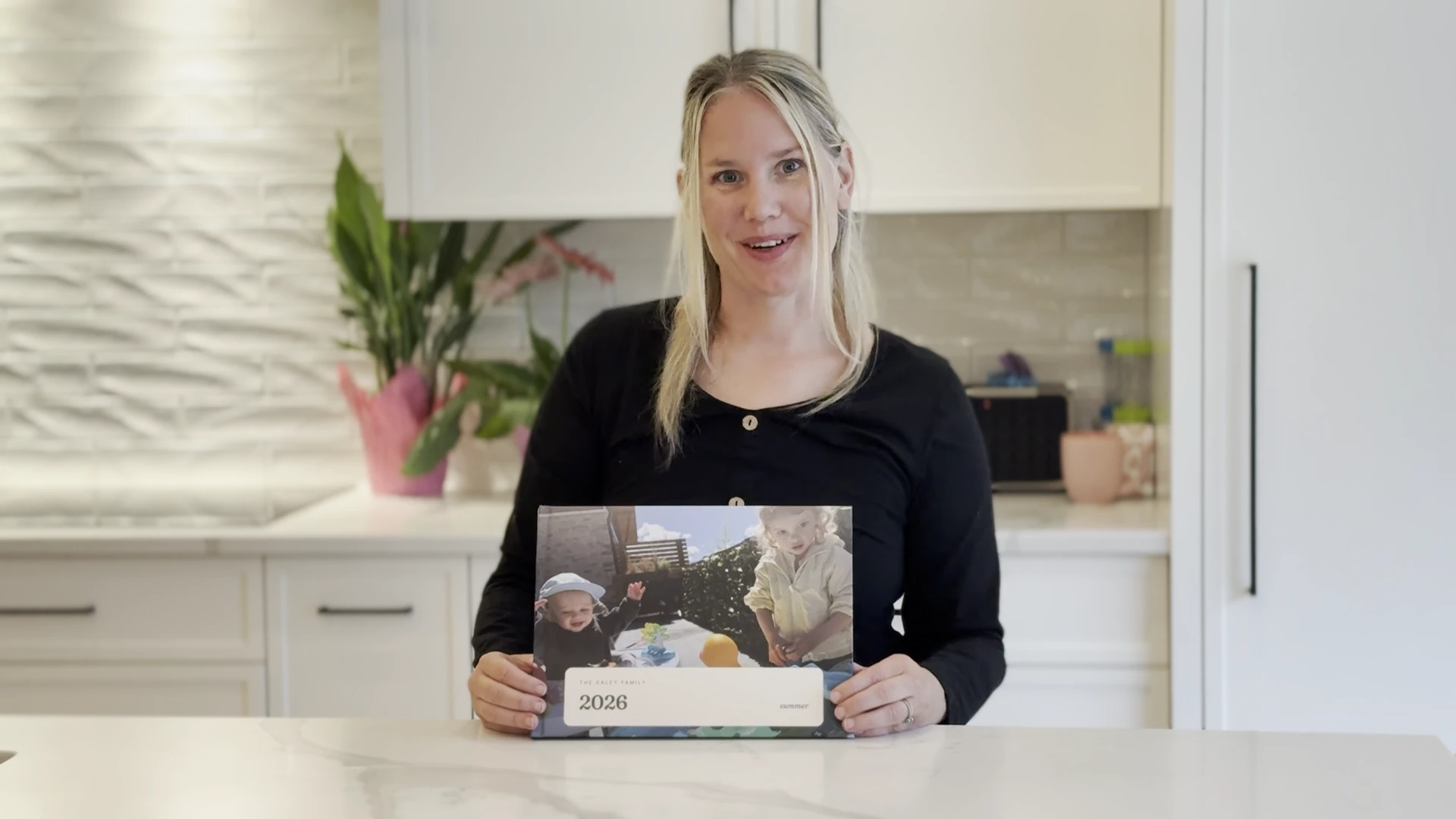 Nicole at home, holding her family book in both hands.
