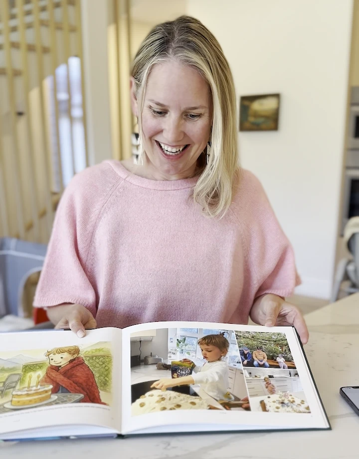 Nicole smiling as she looks through her open family book.