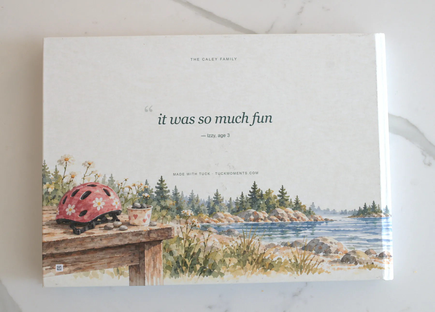 The back cover: one line from the year, it was so much fun, Izzy, age 3, over a watercolor lakeshore.