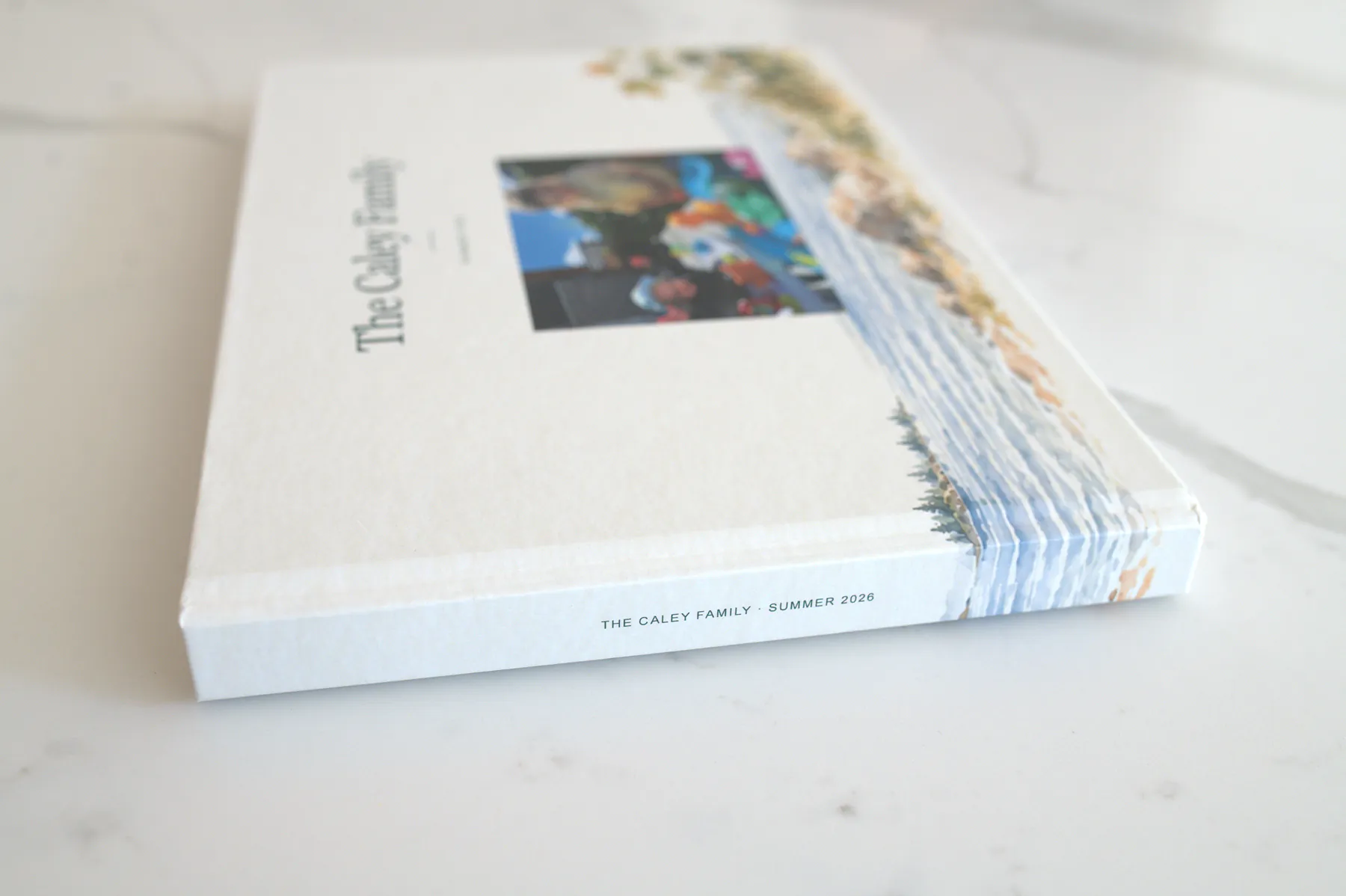 The closed hardcover from the side: the spine reads The Caley Family, Summer 2026.